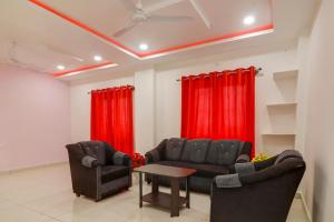 a living room with two couches and red curtains at Hotel O Home RBS Homes in Hyderabad +35 photos