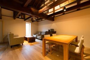 a dining room with a wooden table and chairs at Tsumesyo Mikuni in Sakai