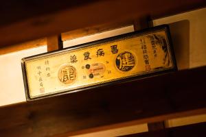 a sign with asian writing on top of a shelf at Tsumesyo Mikuni in Sakai