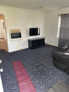 a living room with a couch and a flat screen tv at Two bedroom flat with fire place in Detroit