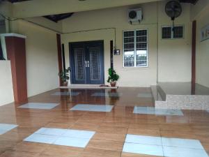 a room with a wooden floor and a black door at Ninizam Kemaman Cukai Homestay in Cukai