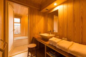 a wooden bathroom with a sink and a mirror at Tsumesyo Mikuni in Sakai