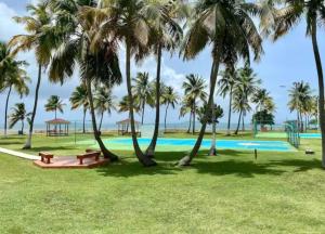 a park with palm trees and a swimming pool at Ocean Zen in Fajardo