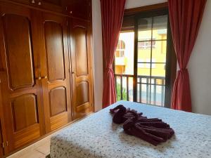 a bedroom with a bed with a table and a room with a window at Bedroom Medanomar 1 in El Médano