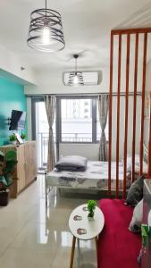 ein Schlafzimmer mit einem Bett und einem Tisch in einem Zimmer in der Unterkunft Stylish New Unit w/ Balcony at Fern Residences in Manila