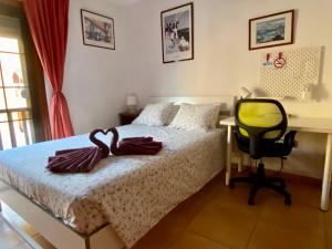 埃爾梅達諾的住宿－Bedroom Medanomar 1，一间卧室配有一张床、一张桌子和一把椅子