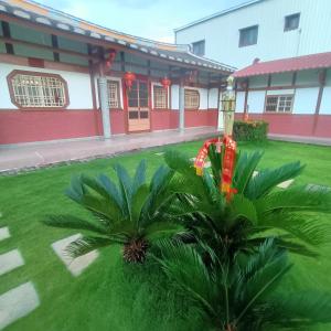 a building with a palm tree in front of a building at J ancient house in Lucao