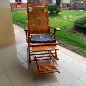 a wooden rocking chair sitting on a porch at J ancient house in Lucao