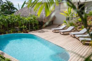 a deck with chairs and a swimming pool at Hôtel Iloma in Sainte-Luce