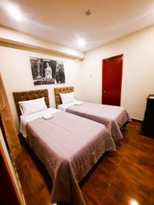 Dos camas en una habitación de hotel con dos en Brianny Hotel en Churín