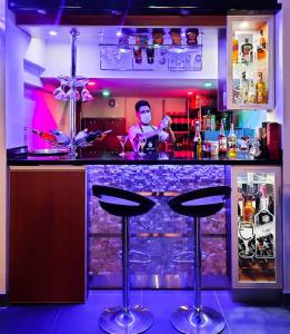 a bar with two bar stools in a room at Brianny Hotel in Churín