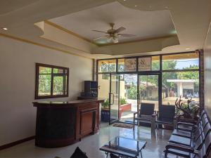 a lobby with a bar with chairs and a ceiling fan at La Casa Milagrosa in Coron