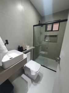 uma casa de banho com um WC e uma cabina de duche em vidro. em Casa de férias São josé Maragogi em São José da Coroa Grande