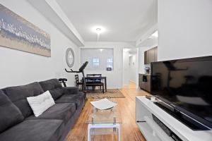 ein Wohnzimmer mit einem Sofa und einem Flachbild-TV in der Unterkunft Cozy Private Room, Walk to Wilson Station in Toronto