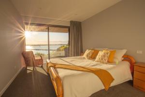 een slaapkamer met een groot bed en een raam bij Beautiful Balmoral Hill Apartment in Christchurch