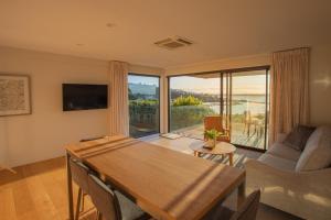 een woonkamer met een tafel en een groot raam bij Beautiful Balmoral Hill Apartment in Christchurch