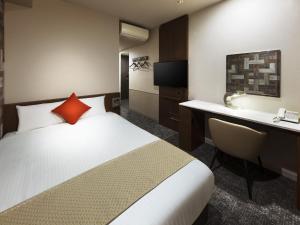 a hotel room with a bed and a desk at Hotel Villa Fontaine Tokyo-hatchobori in Tokyo