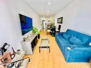sala de estar con sofá azul y TV en Casa Sol Apartamento vista al mar cerca del aeropuerto y Miraflores en Lima