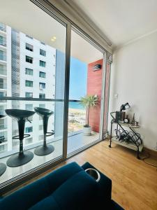 a living room with a large window with a view of the ocean at Casa Sol Apartamento vista al mar cerca del aeropuerto y Miraflores in Lima