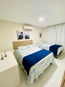 a bedroom with two beds and a sink at Apartamento encantador térreo em condomínio fechad in Porto De Galinhas