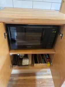 a microwave oven in a wooden cabinet at Brown's Beach Guest Suite in Ucluelet