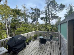 a patio with a table and chairs on a deck at Brown's Beach Guest Suite in Ucluelet