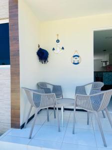 a table and four chairs in a room at Apartamento encantador térreo em condomínio fechad in Porto De Galinhas