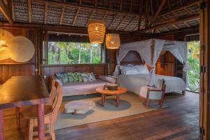 a bedroom with a bed and a table in a room at Oka Maraú I Charming Bungalows in Marau