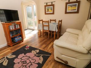 a living room with a couch and a table at 3 Rosecraddoc Lodge in Saint Cleer