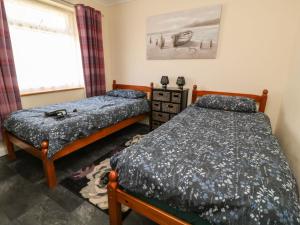 two twin beds in a room with a window at 3 Rosecraddoc Lodge in Saint Cleer
