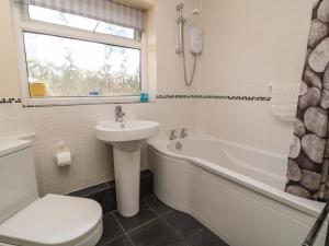 a bathroom with a sink and a tub and a toilet at 3 Rosecraddoc Lodge in Saint Cleer +9 photos