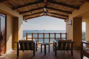 Habitación con sillas y vistas al océano. en Cala de Mar Resort & Spa Ixtapa en Ixtapa