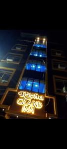 a building with a lit up sign in front of it at Flagship Richa Grand Inn Near Sahara Ganj Mall in Lucknow