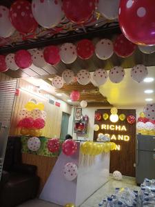 a room with red and white balloons and a table with a sign at Flagship Richa Grand Inn Near Sahara Ganj Mall in Lucknow