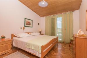 a bedroom with a bed and a large window at Apartment Green Peace in Zadvarje