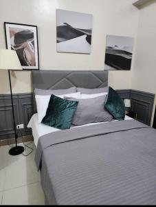 a bedroom with a large bed and pictures on the wall at Cozy Studio Unit near Uptown Mall BGC in Manila