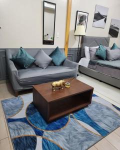 a living room with a couch and a coffee table at Cozy Studio Unit near Uptown Mall BGC in Manila