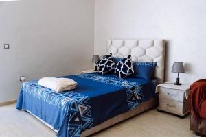 a bedroom with a bed with blue sheets and pillows at Cozy New Studio in Mohammedia in Mohammedia
