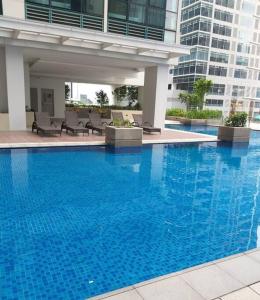 a large blue swimming pool in a building at Cozy Studio Unit near Uptown Mall BGC in Manila
