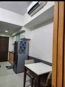 a kitchen with a table and a refrigerator at Cozy Studio Unit near Uptown Mall BGC in Manila