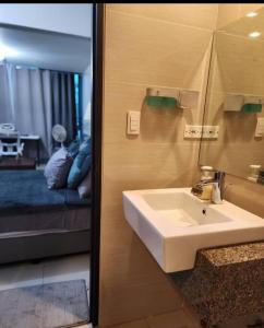 a bathroom with a sink and a mirror and a bed at Cozy Studio Unit near Uptown Mall BGC in Manila