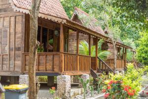 Jukung Cottage في نوسا بينيدا: منزل خشبي في الغابة مع شجرة