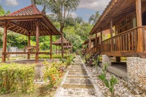 a garden with a wooden house and a pathway at Jukung Cottage in Nusa Penida