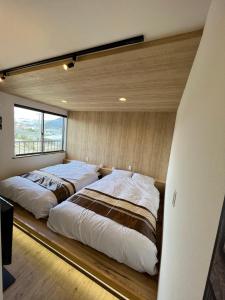 two beds sitting on a woodeninylinylinylinylinylinylinyl at CLIMB INN COCOMO in Sumoto