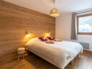 a bedroom with a large bed with a wooden wall at Appartement Valmorel, 3 pièces, 6 personnes - FR-1-291-889 in Valmorel