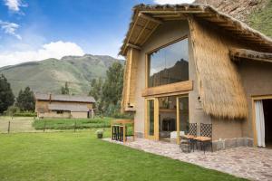 ein Haus mit einem Strohdach und einem Hof in der Unterkunft CASA REBEQ in Cusco