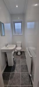 een badkamer met een wastafel, een toilet en een bad bij Warwick St by Prestige Properties SA in Barrow in Furness