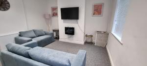 a living room with a couch and a tv at Warwick St by Prestige Properties SA in Barrow in Furness