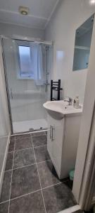 een witte badkamer met een wastafel en een douche bij Warwick St by Prestige Properties SA in Barrow in Furness