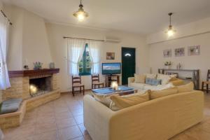 a living room with two couches and a fireplace at Traditional Ioannis Cottage in Nerokhórion